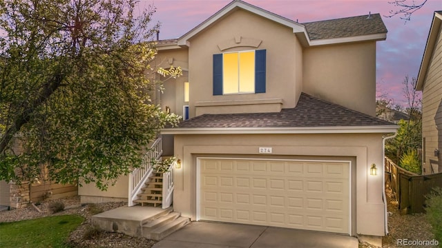 274 W Willowick Cir, Highlands Ranch, CO 80129 - view of front of home featuring a shingled roof, stairway, stucco siding, driveway, and an attached garage