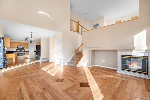 274 W Willowick Cir, Highlands Ranch, CO 80129 - unfurnished living room featuring stairway, a fireplace, and a high ceiling
