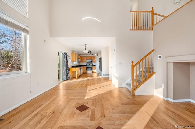 274 W Willowick Cir, Highlands Ranch, CO 80129 - unfurnished living room with a high ceiling, stairway, and a chandelier