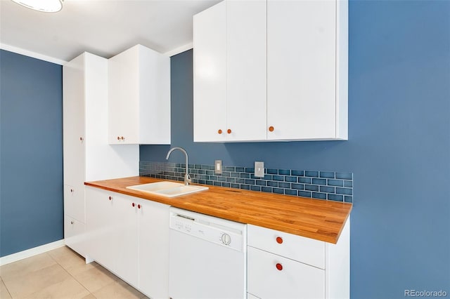 kitchen with butcher block countertops, dishwasher, light tile patterned floors, decorative backsplash, and a sink