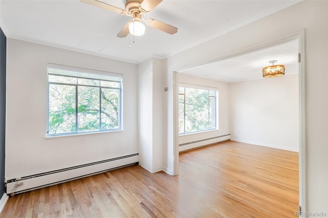 spare room featuring ceiling fan, baseboards, a baseboard heating unit, and light wood-style floors