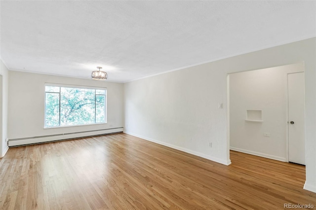 empty room with crown molding, baseboards, wood finished floors, a notable chandelier, and a baseboard radiator