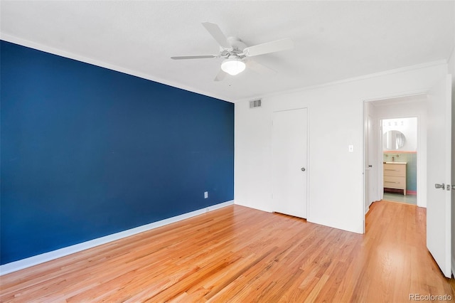 unfurnished bedroom featuring a ceiling fan, visible vents, baseboards, light wood-style flooring, and a closet