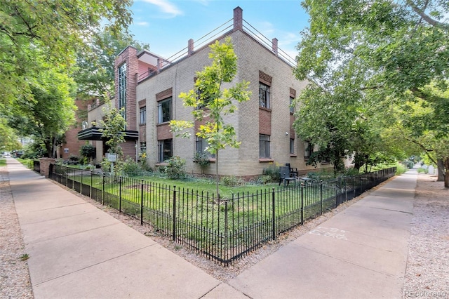 view of home's exterior featuring fence and brick siding