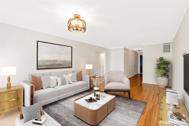 living area featuring visible vents and wood finished floors