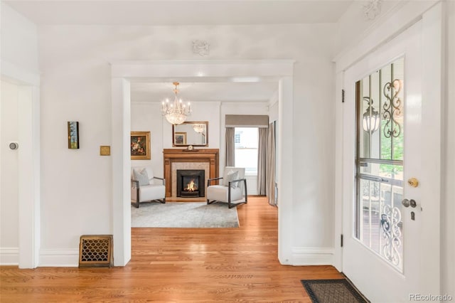 506 N Marion St, Denver, CO 80218 - foyer featuring light wood-style flooring, a chandelier, baseboards, and a lit fireplace