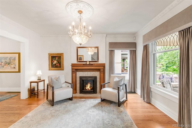 506 N Marion St, Denver, CO 80218 - living area featuring a chandelier, light wood-style flooring, a lit fireplace, baseboards, and crown molding