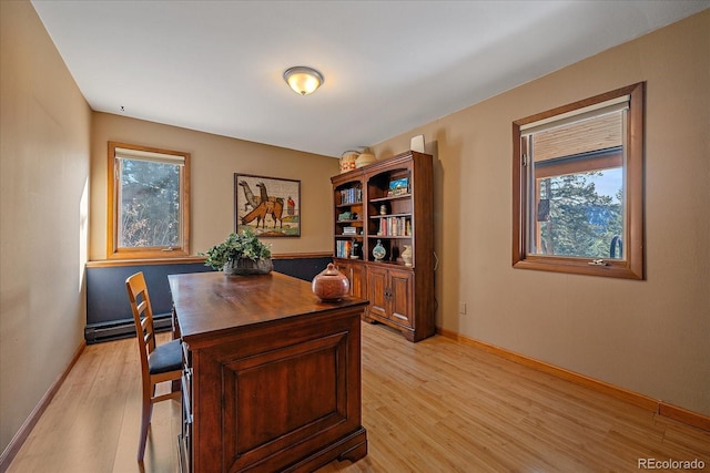 office area featuring baseboards, baseboard heating, a wealth of natural light, and light wood-style floors