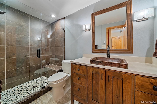 bathroom with a stall shower, vanity, and toilet