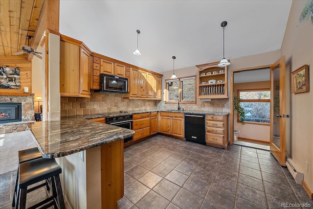 kitchen with a baseboard radiator, a peninsula, a fireplace, backsplash, and black appliances