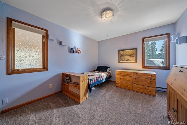 bedroom with a baseboard heating unit, carpet, and baseboards