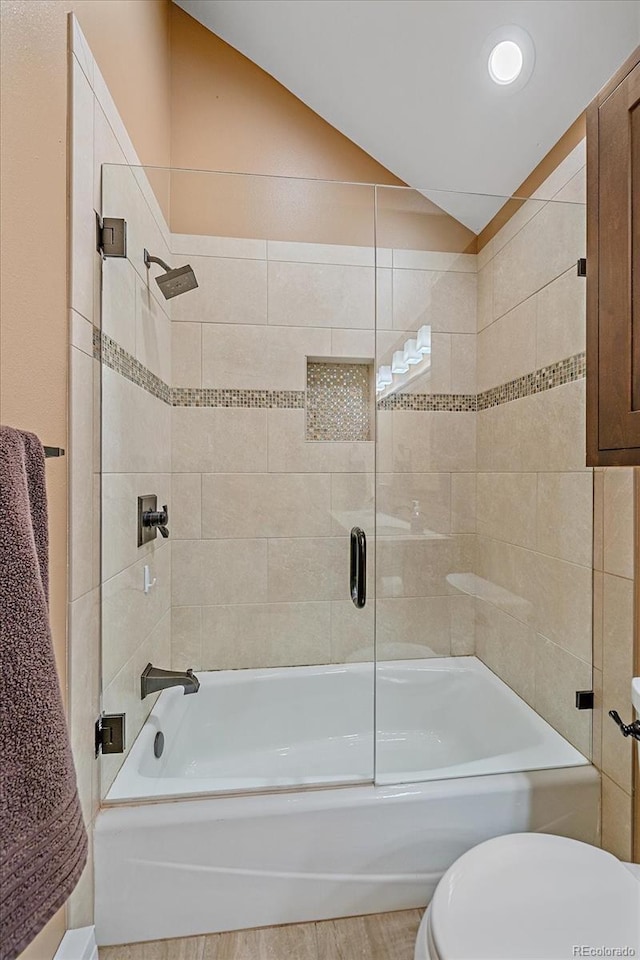 full bath featuring toilet, shower / bath combination with glass door, and vaulted ceiling