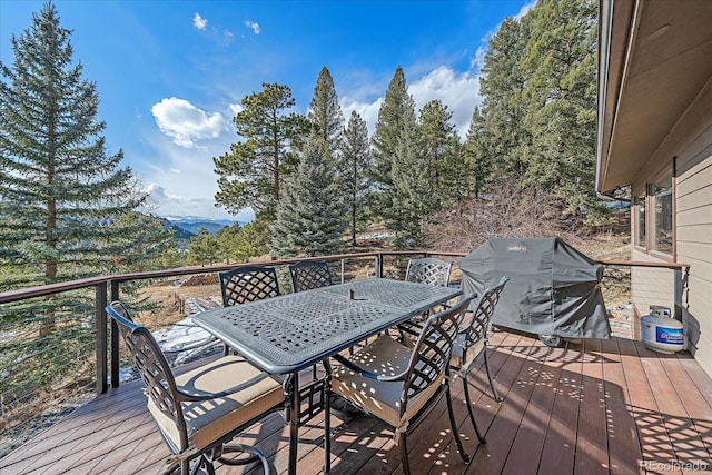 wooden deck featuring outdoor dining area and grilling area