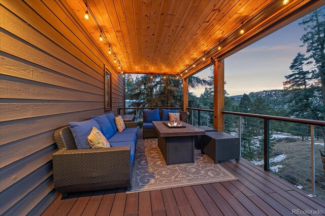 wooden deck with an outdoor living space with a fire pit