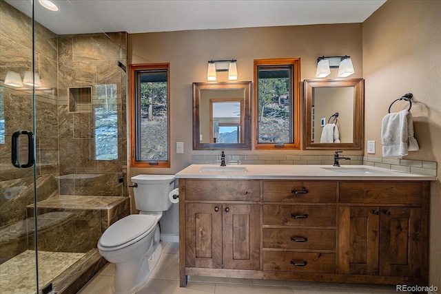 bathroom with a stall shower, a sink, and toilet