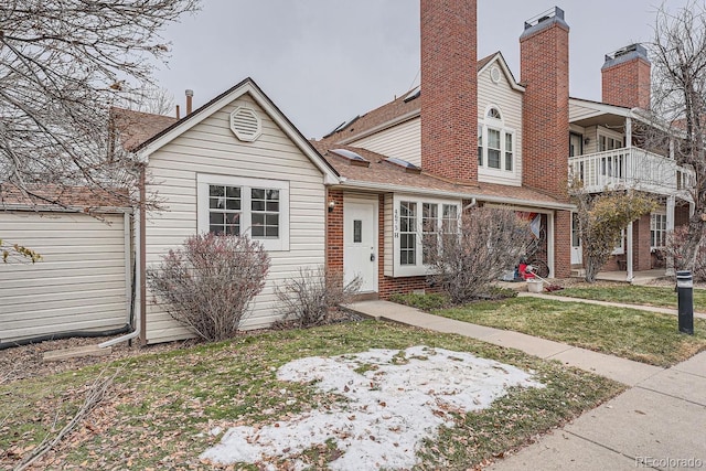 view of front of house with a balcony and a front lawn