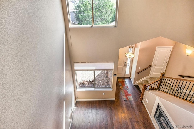 entryway featuring stairway, baseboards, a textured wall, and wood finished floors