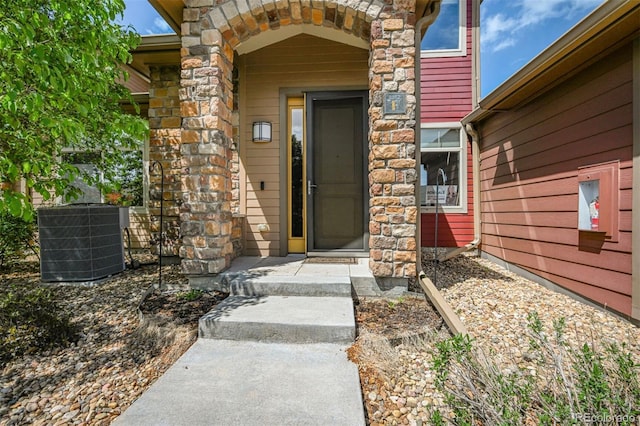 entrance to property with stone siding and cooling unit