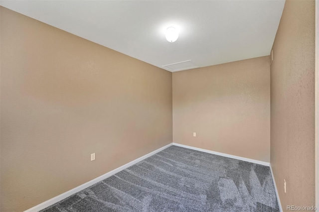 carpeted spare room featuring baseboards
