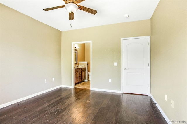 unfurnished bedroom featuring baseboards, connected bathroom, dark wood-style flooring, and a ceiling fan