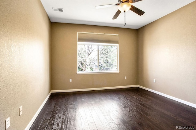 unfurnished room with visible vents, a textured wall, baseboards, dark wood-type flooring, and a ceiling fan
