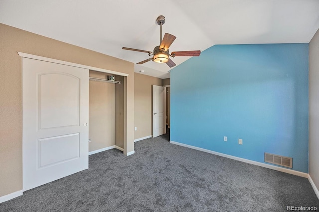 unfurnished bedroom featuring visible vents, a closet, lofted ceiling, baseboards, and carpet flooring