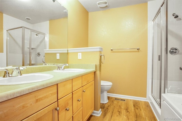 full bath featuring wood finished floors, visible vents, a sink, and a stall shower