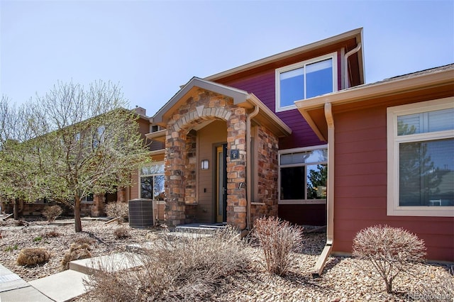 view of front of house featuring central air condition unit and stone siding