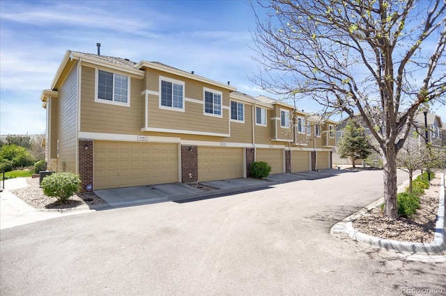 16062 E Geddes Dr Unit 150, Aurora, CO 80016 - view of side of property featuring brick siding, an attached garage, and a residential view