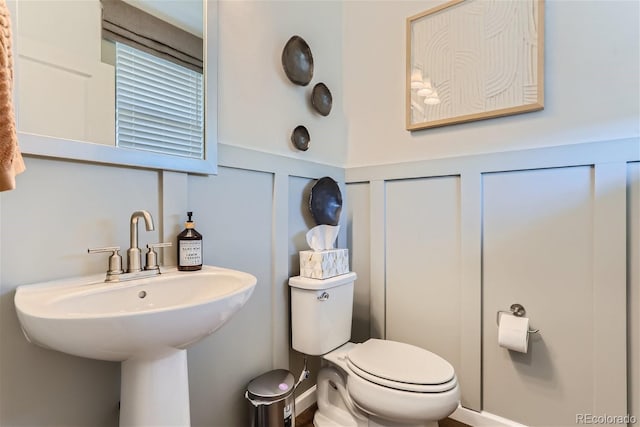 14133 Deertrack Ln, Parker, CO 80134 - half bath featuring toilet, a decorative wall, and wainscoting