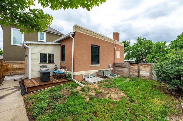 1803 E 36th Ave, Denver, CO 80205 - rear view of property featuring a deck, a fenced backyard, stucco siding, and a chimney