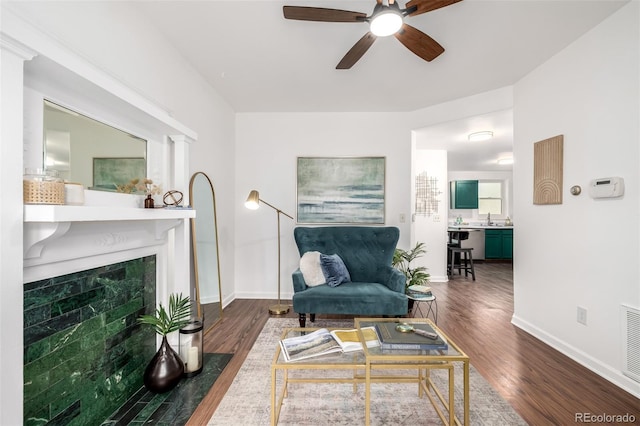 1803 E 36th Ave, Denver, CO 80205 - living room with wood finished floors, a ceiling fan, baseboards, and a tiled fireplace