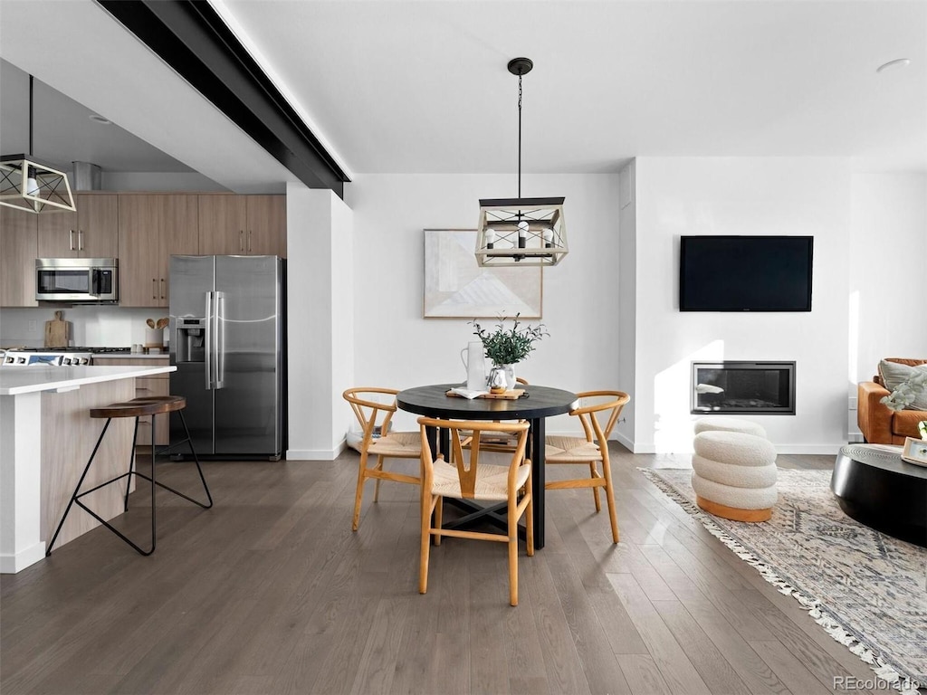 8711 E Hampden Ave Unit 20, Denver, CO 80231 - dining space featuring baseboards, wood finished floors, and a glass covered fireplace