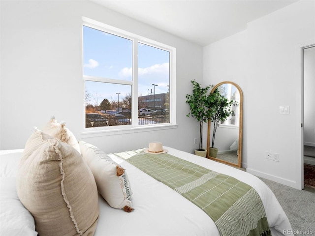 carpeted bedroom with multiple windows and baseboards