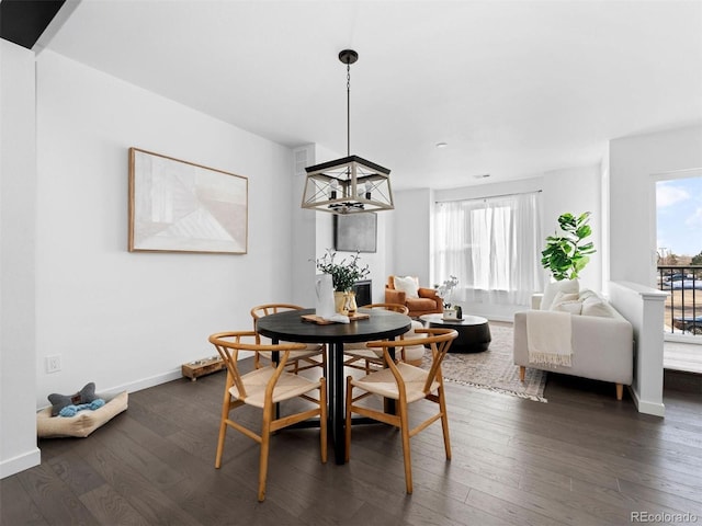 dining room featuring a chandelier, dark wood-style flooring, and baseboards