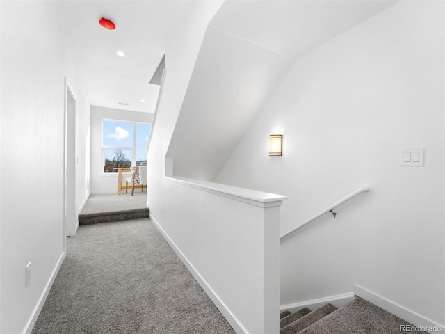 corridor featuring carpet floors, baseboards, an upstairs landing, vaulted ceiling, and recessed lighting