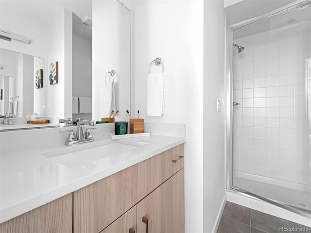 full bath featuring a shower stall, vanity, tile patterned floors, and baseboards