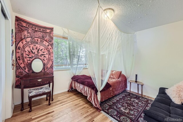 bedroom with a textured ceiling and light wood-type flooring