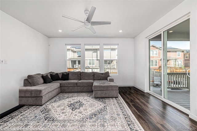 living room featuring dark wood-type flooring and ceiling fan