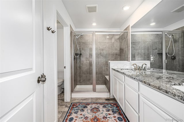 bathroom with vanity, toilet, and a shower with shower door