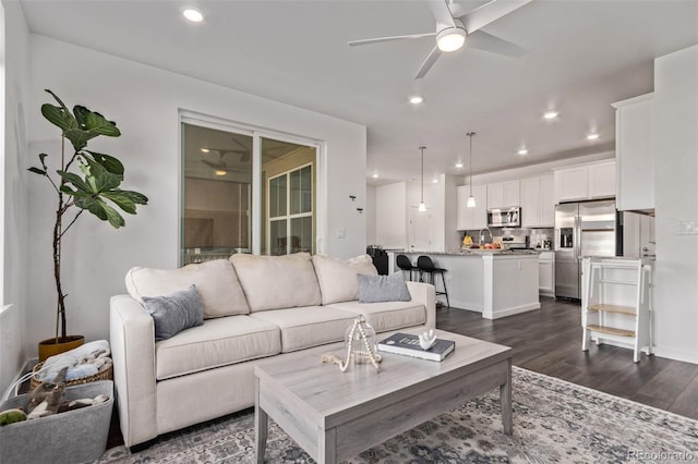 living room featuring ceiling fan, dark wood-type flooring, and recessed lighting