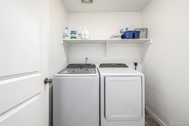 clothes washing area featuring laundry area, washing machine and dryer, and baseboards