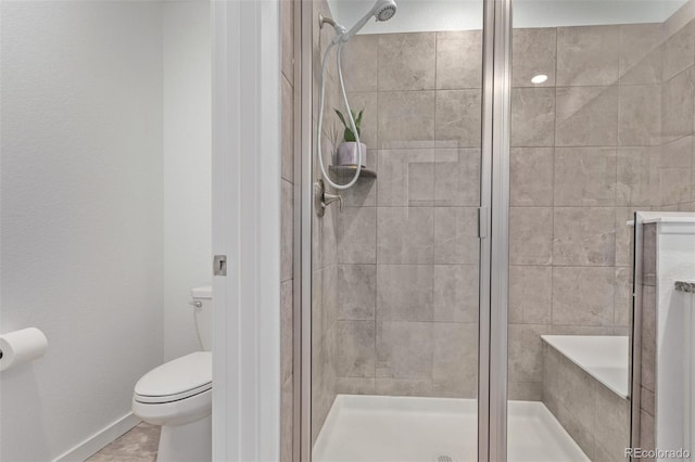 full bath featuring toilet, a stall shower, and baseboards