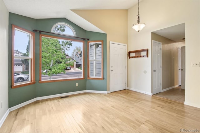 17943 E Bates Ave, Aurora, CO 80013 - empty room featuring wood finished floors, vaulted ceiling, and baseboards