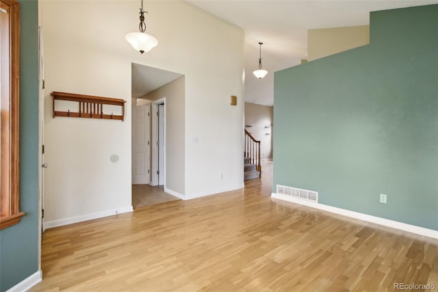 17943 E Bates Ave, Aurora, CO 80013 - spare room with light wood-style floors, stairway, baseboards, and high vaulted ceiling