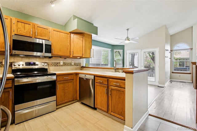 17943 E Bates Ave, Aurora, CO 80013 - kitchen featuring appliances with stainless steel finishes, a sink, a peninsula, ceiling fan, and decorative backsplash