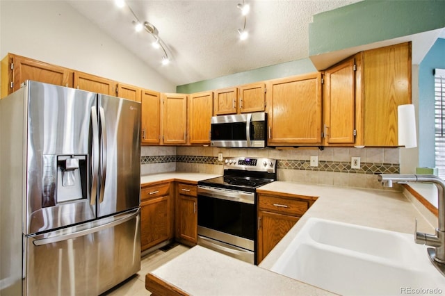 17943 E Bates Ave, Aurora, CO 80013 - kitchen featuring appliances with stainless steel finishes, a sink, light countertops, backsplash, and vaulted ceiling