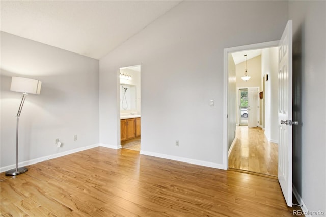 17943 E Bates Ave, Aurora, CO 80013 - unfurnished bedroom with light wood-style floors, high vaulted ceiling, baseboards, and ensuite bathroom