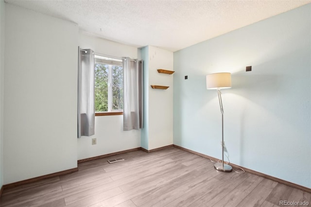 17943 E Bates Ave, Aurora, CO 80013 - unfurnished room with wood finished floors, a textured ceiling, and baseboards