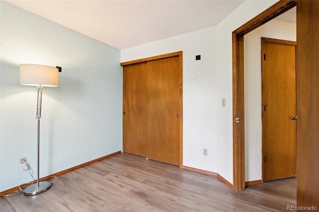 17943 E Bates Ave, Aurora, CO 80013 - unfurnished bedroom with wood finished floors, a closet, and baseboards
